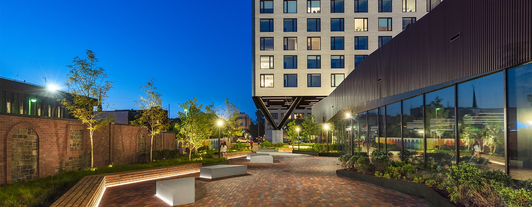 a walkway outside of a large building with benches